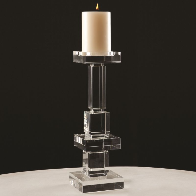 A tall, modern candle holder with a clear glass design, featuring two levels and holding a white pillar candle.