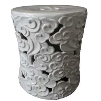 This image shows a large white ceramic stool with an intricate floral swirl design patterned throughout its surface The glaze of each