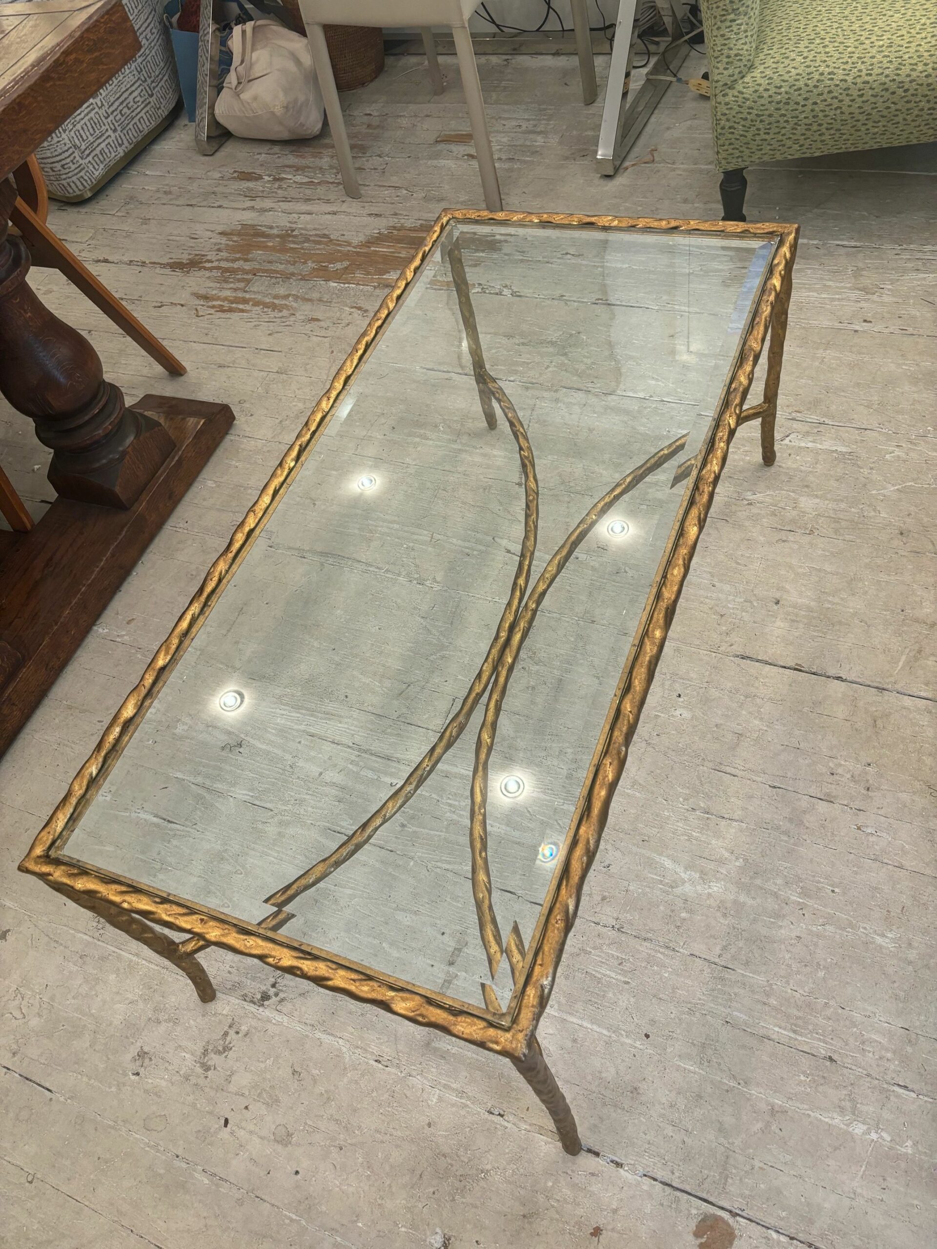 Close-up of gilded metal twist coffee table showcasing intricate design and gold leaf finish on twisted metal.