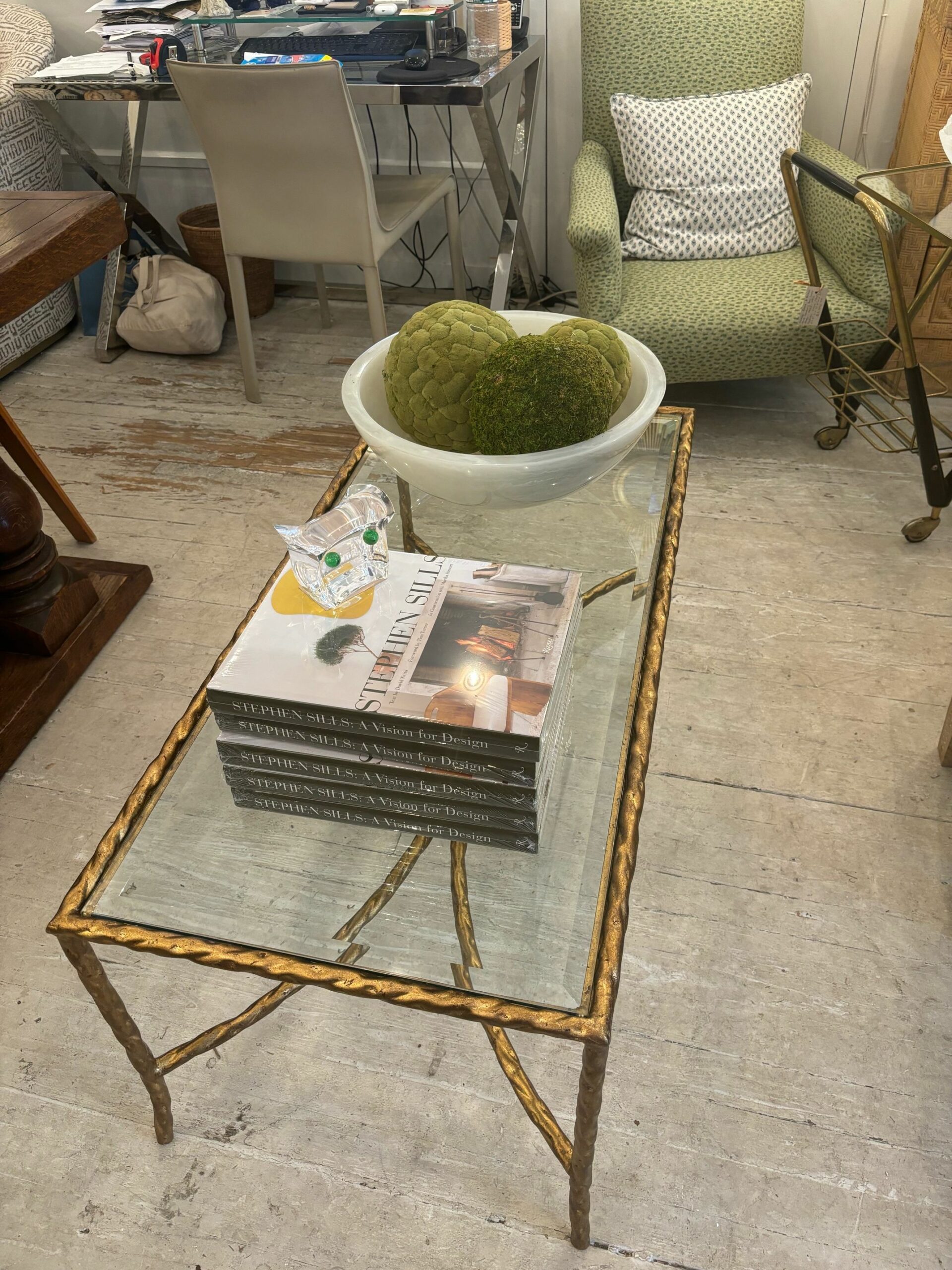 The Gilded Metal Twist Coffee Table is an elegant piece of furniture featuring a rectangular shape with twisted metal accents that evoke