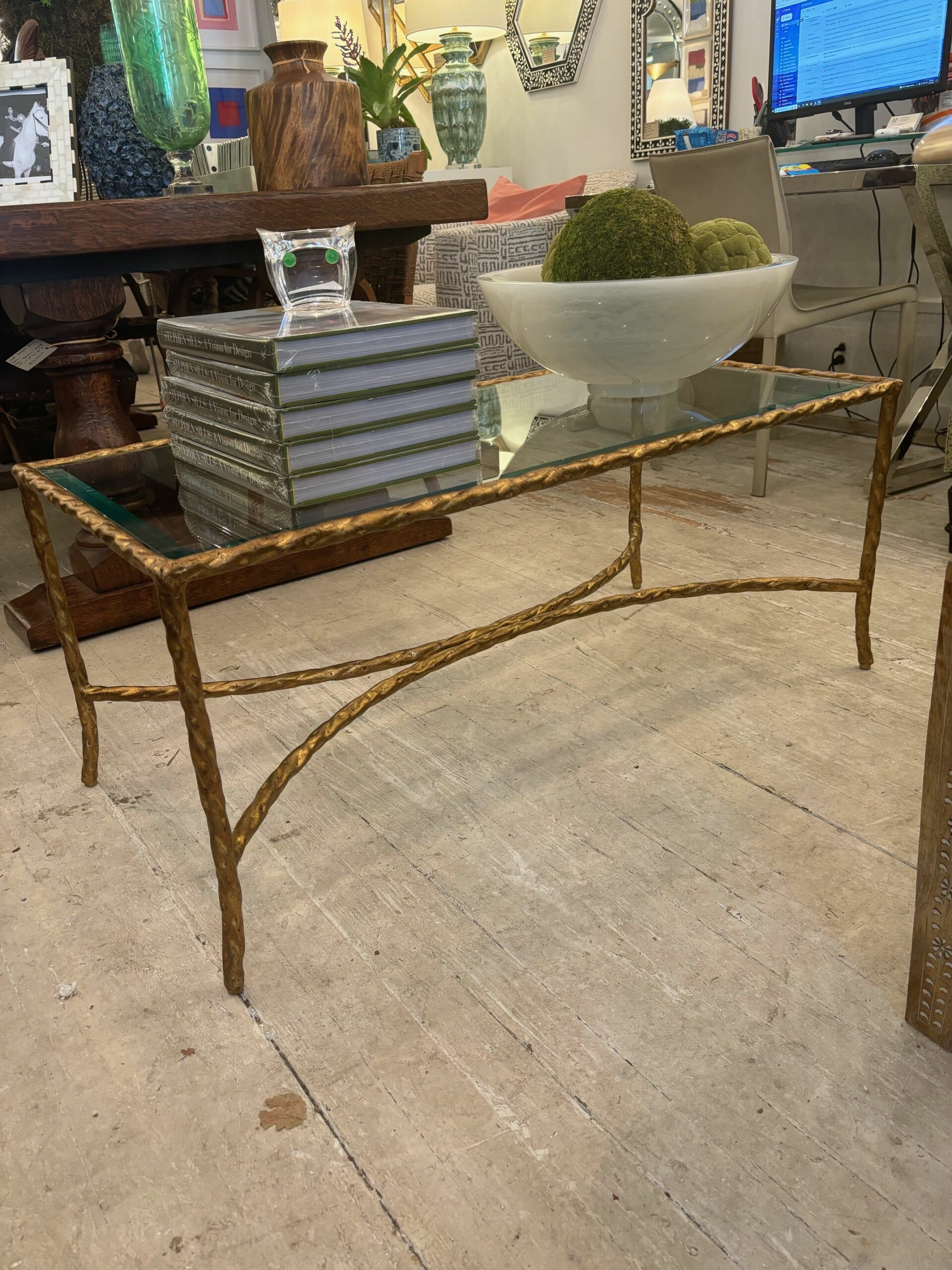 Gold-finished rectangular coffee table with twisted metal frame, glass top.