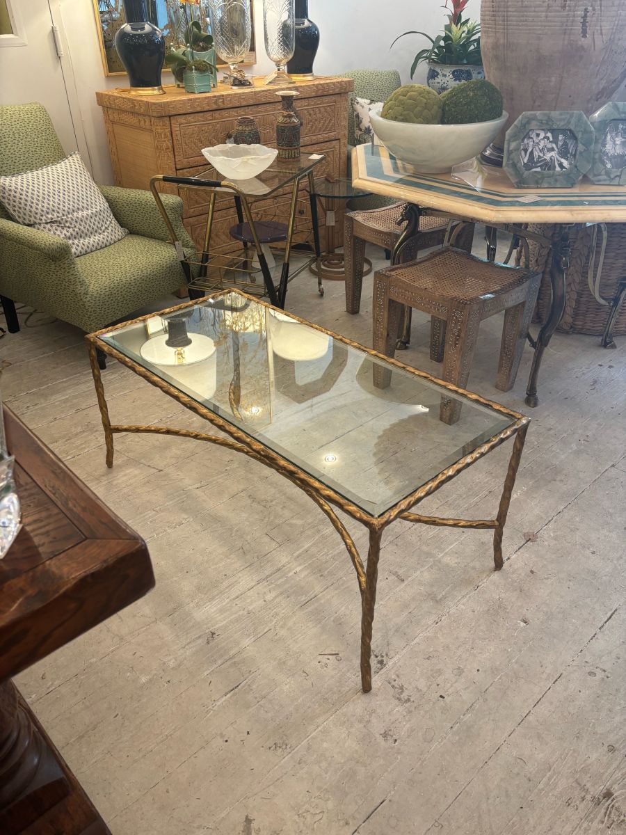 Gilded bronze finish rectangular coffee table with twisted metal frame and glass top, showcasing intricate design.