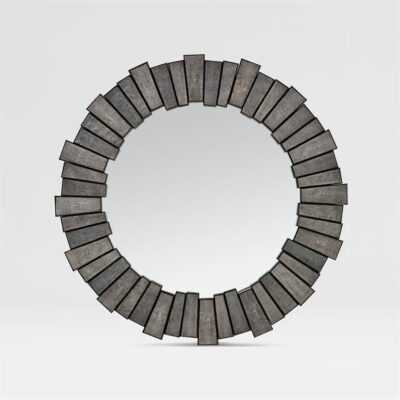 This is a photograph of a round wall mirror encircled by a circular array of metal elements that resemble shagreen patterned tiles
