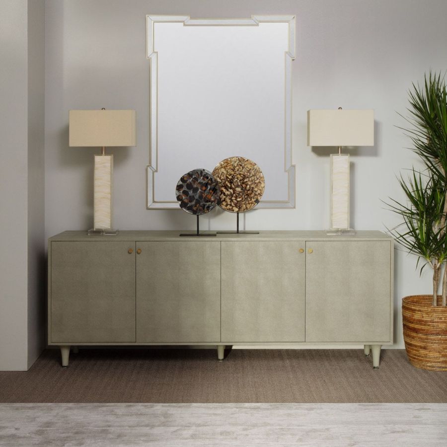 Nadine Mirror in Antiqued Frame, showcasing elegant cut panels against a light blue wall and white floor.