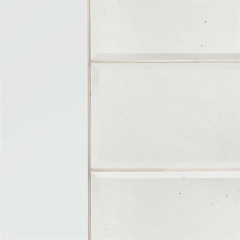 A white, rectangular wall mirror with four panels of glass, bordered by a light pink frame, set against a white background.