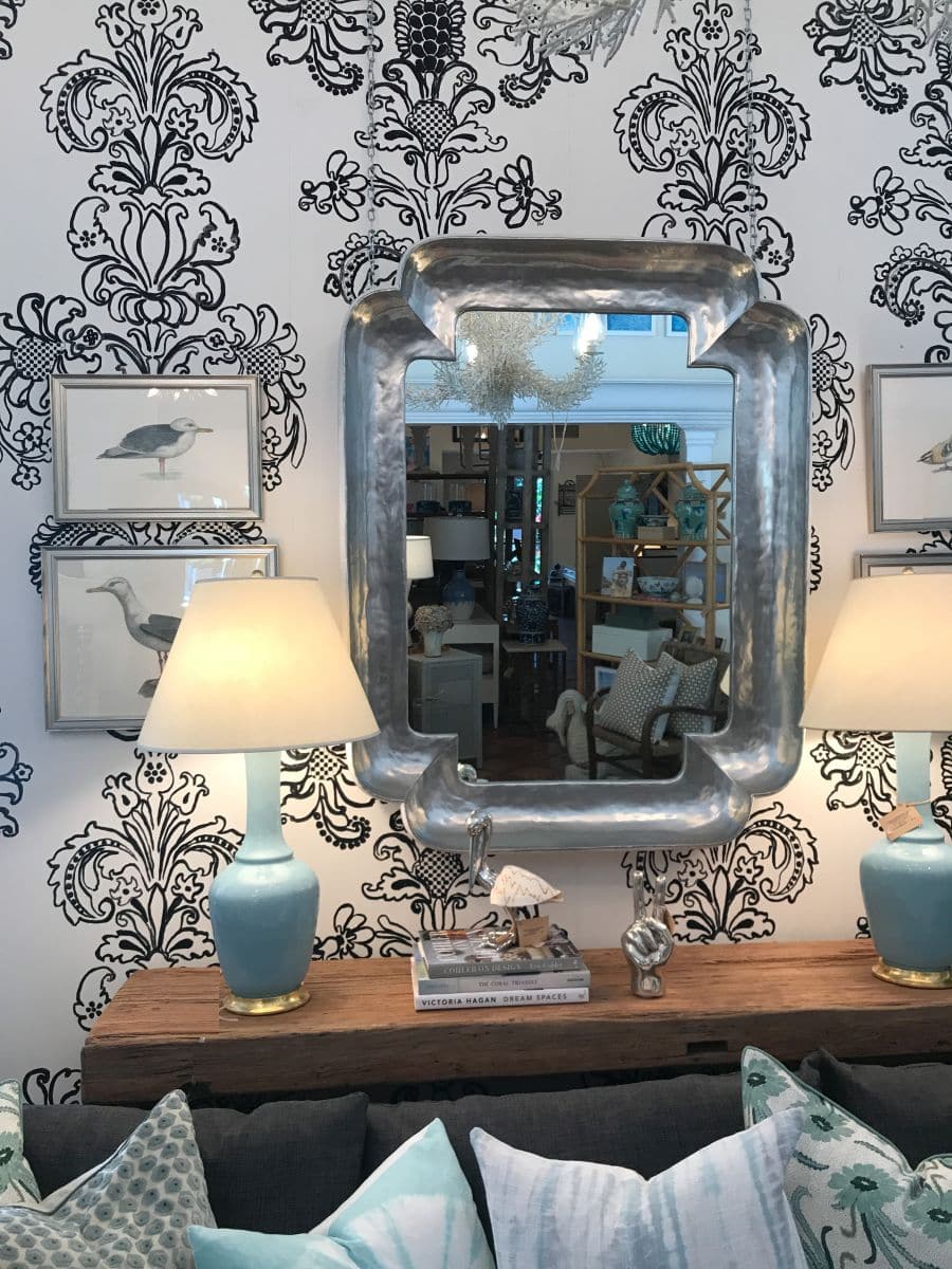Stylish small clipped corner mirror with white frame, reflecting elegant interior design.