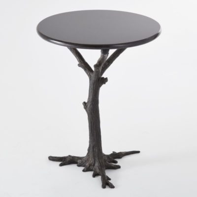 Dark wood and marble side table with a bronze base and a tree branch design on top, standing against a white background.