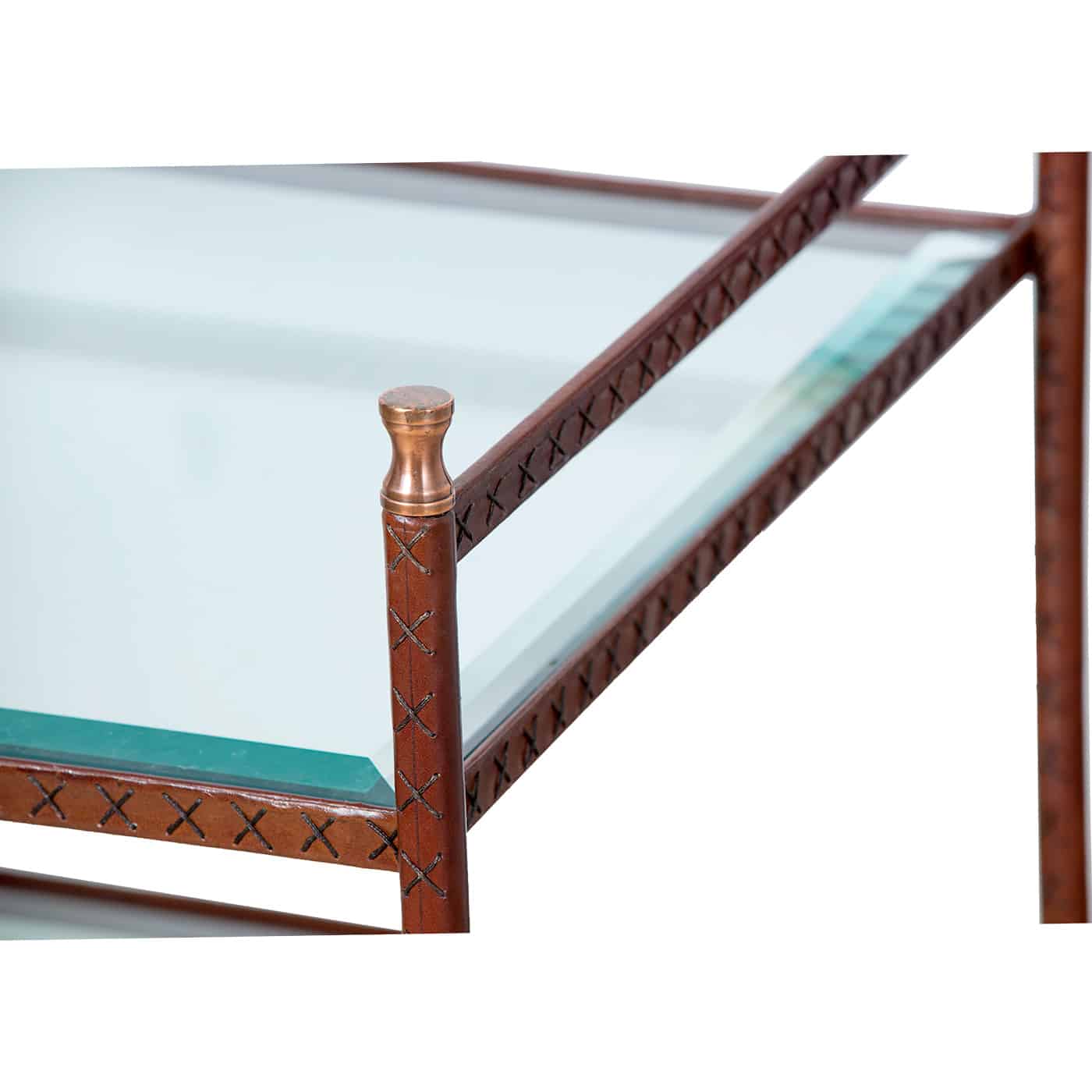 A wooden side table with a glass shelf and brass finials wrapped in leather with visible stitching details showcasing its design and