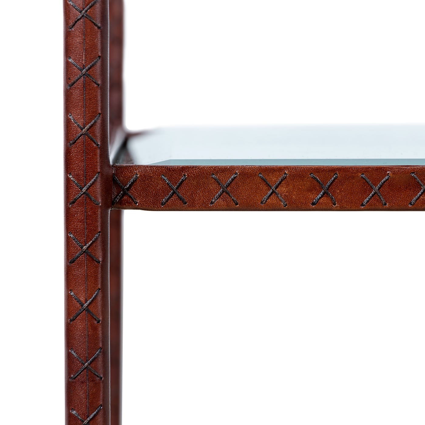 Leather wrapped side table with glass shelves and brass finials, featuring a modern design.