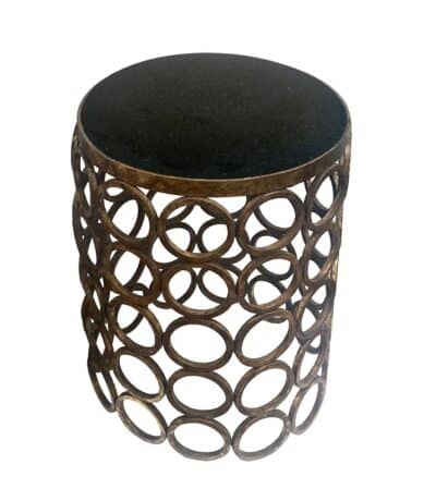 Elegant circular side table with intricate metalwork, featuring a granite top and iron base in gold finish.