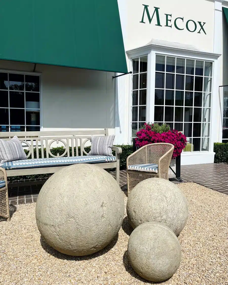 Large concrete spheres in dark gray and distressed lightly beige gray, available in three sizes.