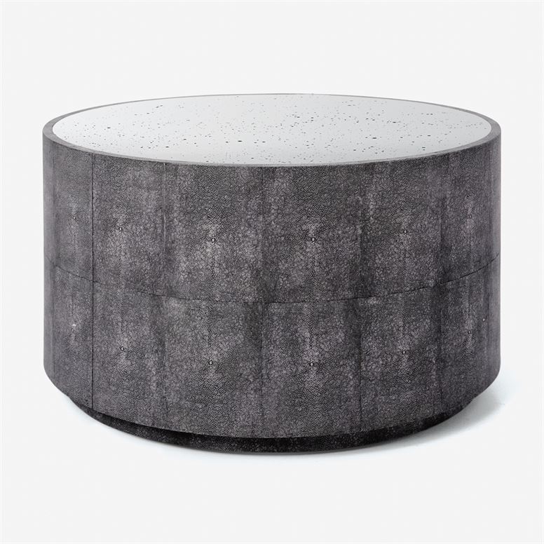 The image features a modern round coffee table with a unique gray faux shagreen top It has an antiqued mirror finish that
