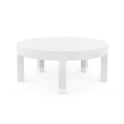 Stylish round coffee table with white washed linen top, silver sabots, and elegant design.