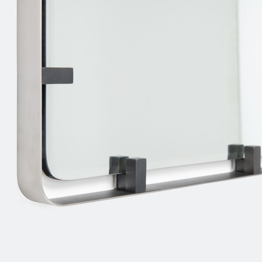 Modern wall-mounted mirror with sleek metal clip available in pewter, bronze, or matte brass finishes.