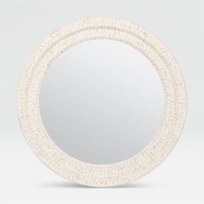 Large round mirror with a tan and white bone frame.