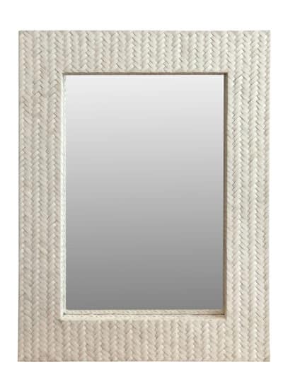 The image shows a close-up of a woven basket frame mirror with a bone white finish and a rectangular shape set against