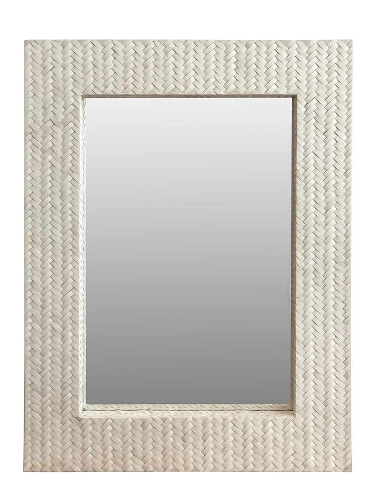 The image shows a close-up of a woven basket frame mirror with a bone white finish and a rectangular shape set against