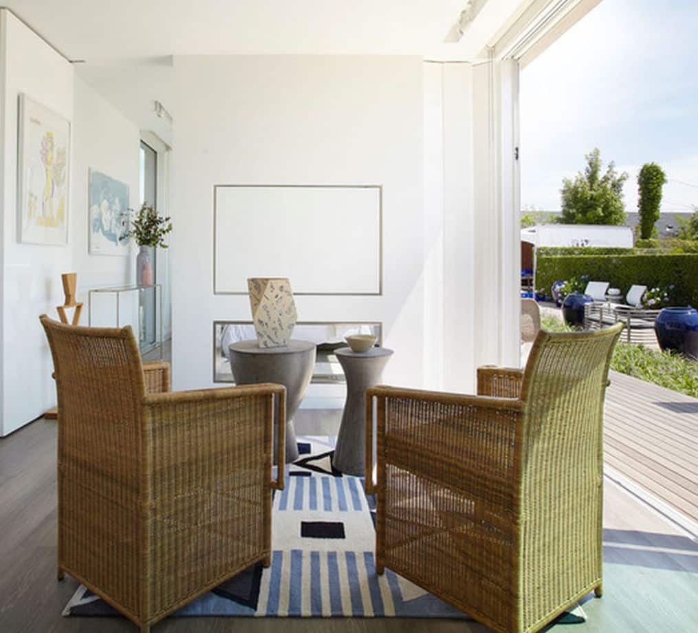 The image displays an outdoor patio area with a modern and inviting atmosphere A large wicker chair is positioned in the foreground