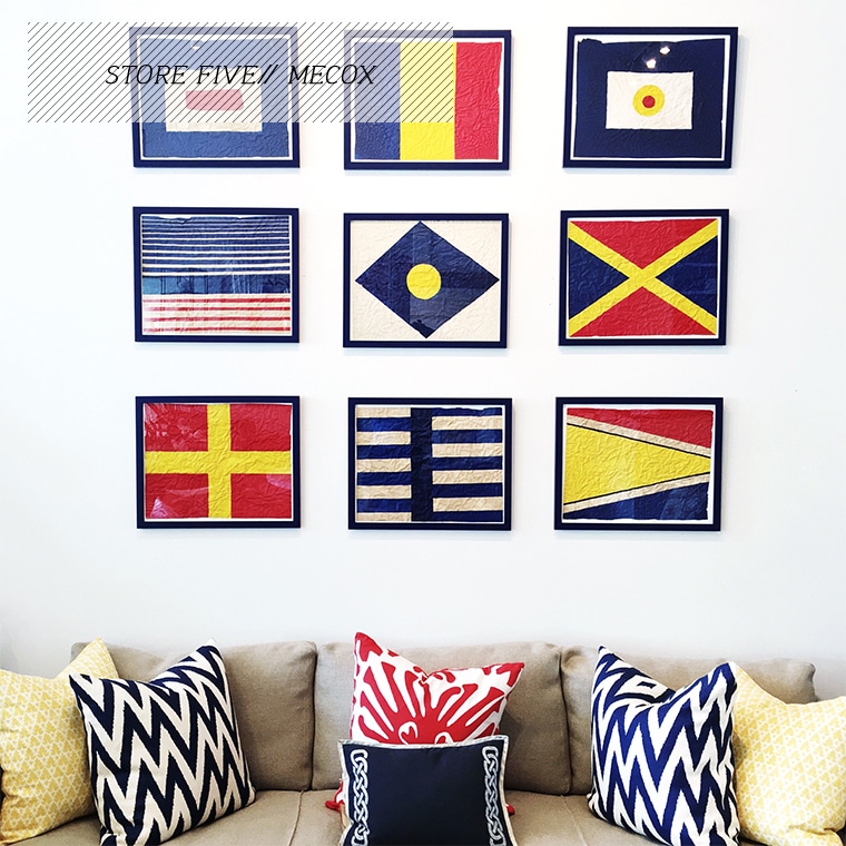 A collection of six framed flags hanging on a wall, each with different designs and colors, creating a diverse and vibrant display.