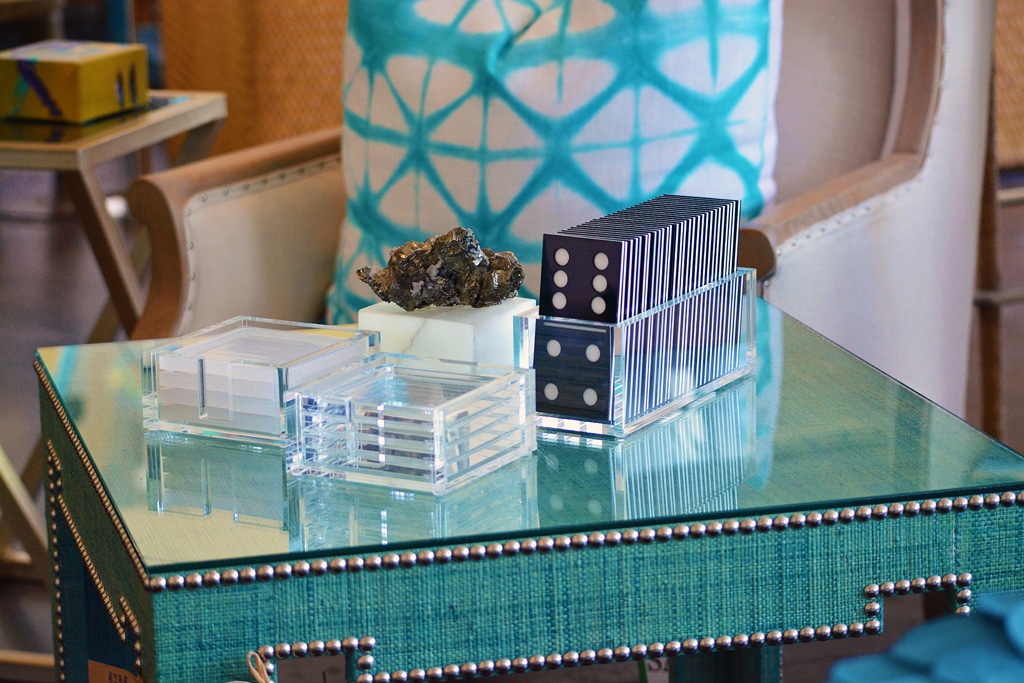 Acrylic domino set on glass table with blue and white patterned cushion in background
