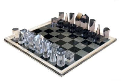 Black and white acrylic chess set with clear pieces on a checkered board
