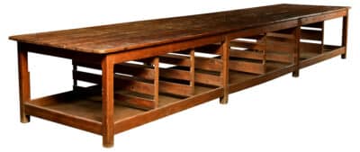 Wooden antique factory work table with shelves, used for cutting cloth in Hasselt, Belgium.