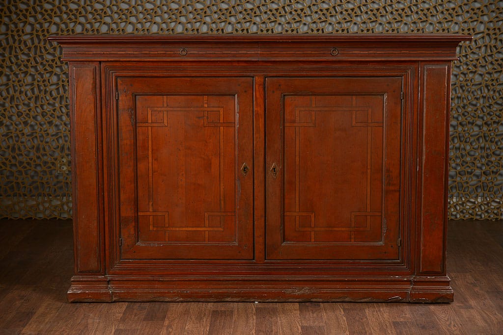 Wooden buffet with two doors and two upper drawers, featuring a dark wood finish and intricate inlay designs on the doors.