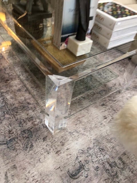 Glass and acrylic coffee table with a bottom glass shelf and tempered glass top displayed on a patterned carpeted floor in a