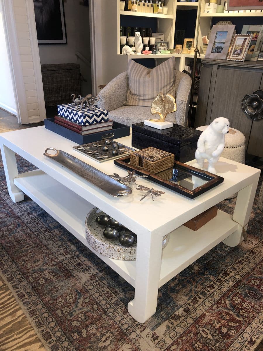 Ming Style Faux Raffia Coffee Table on display in store, French Gray finish.