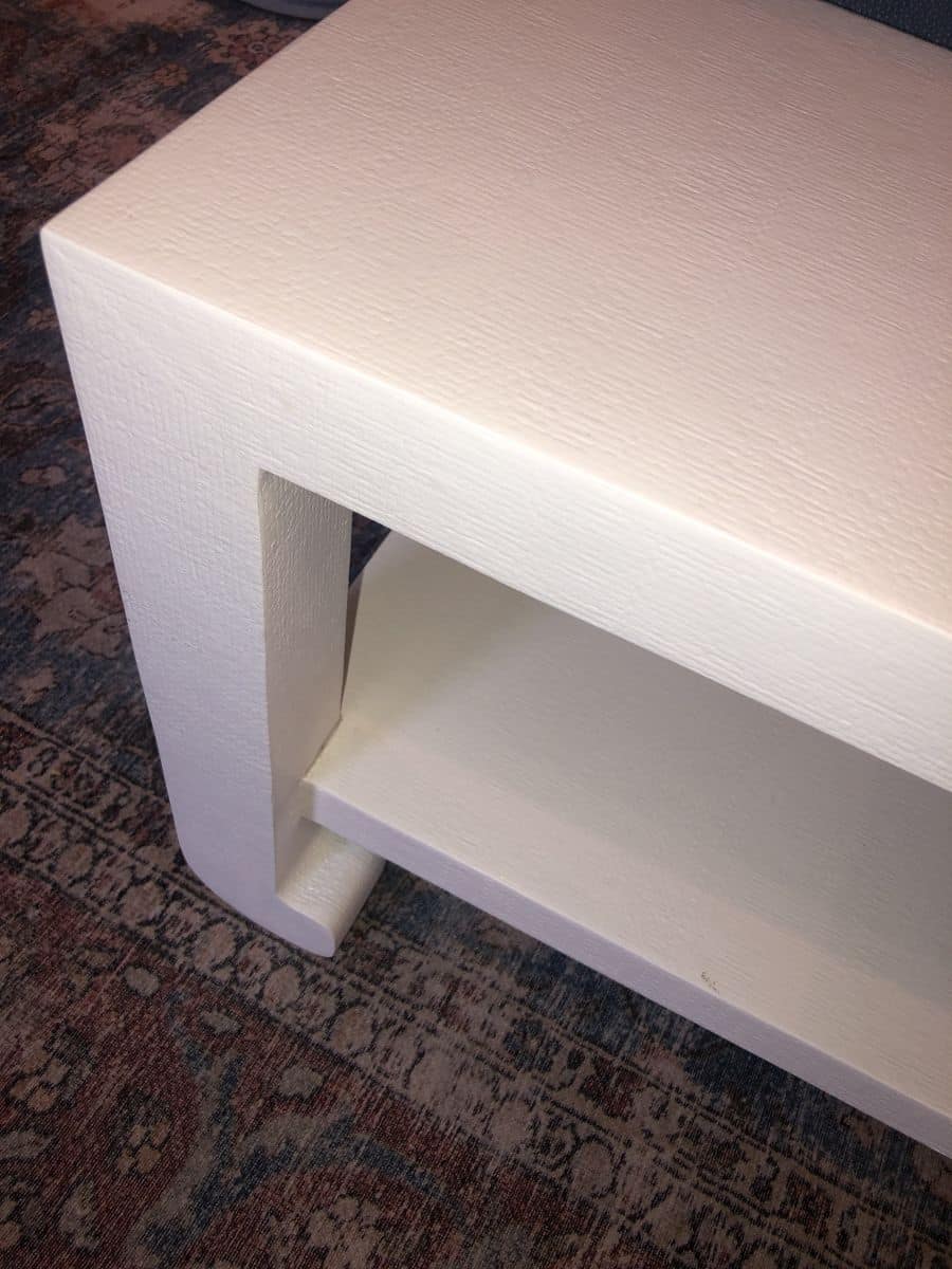 Ming style white coffee table in a room with a patterned carpet.