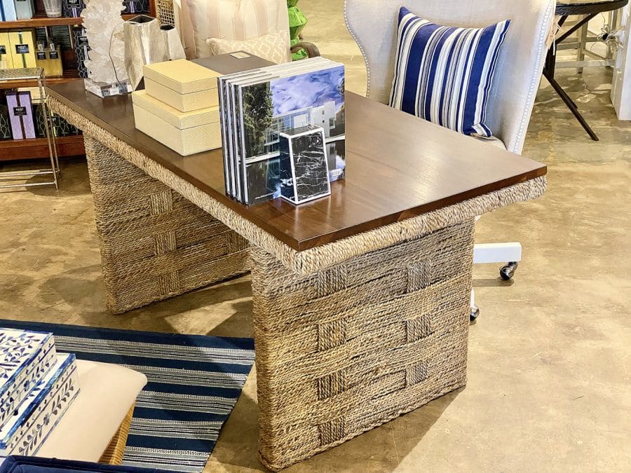 Close-up of Colby Teak and Woven Desk, featuring interwoven rope base and teak top in a warm brown tone.