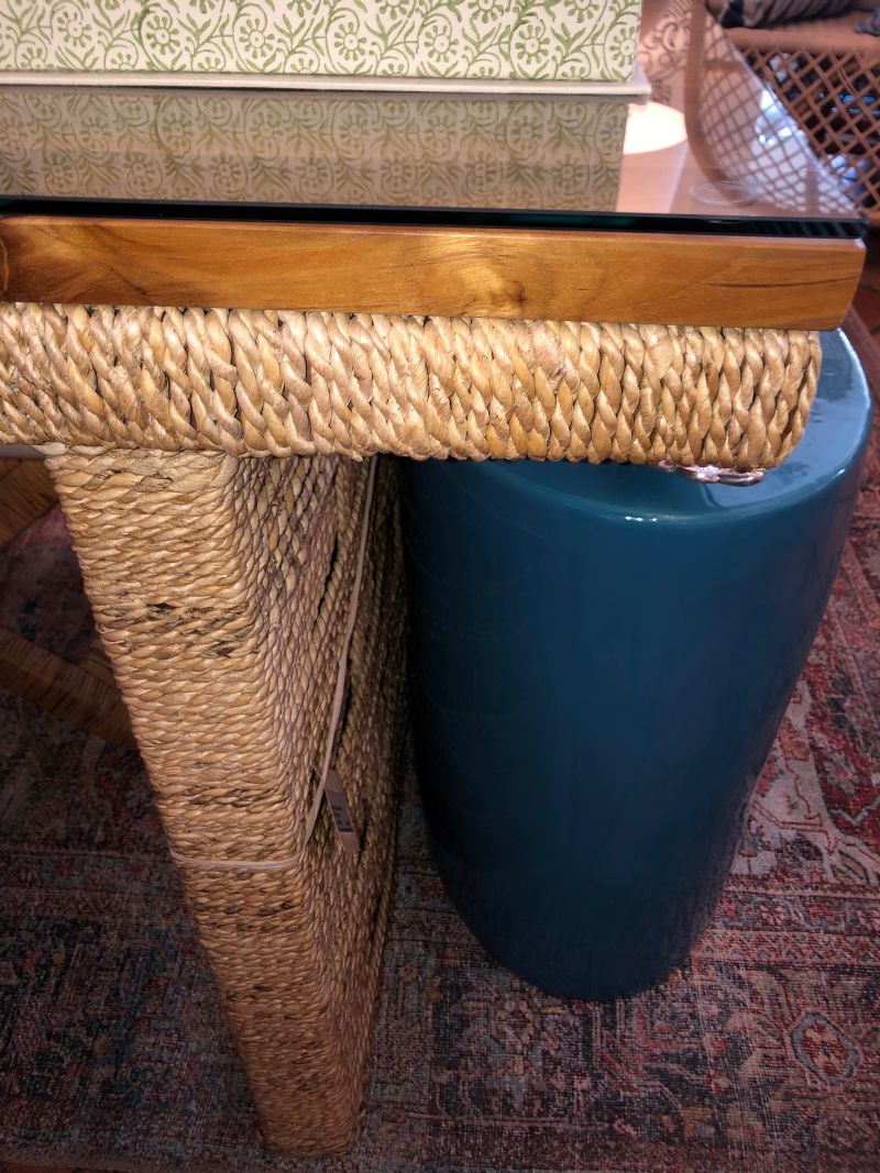 A woven basket with a teak base and top part of a Colby Teak and Woven Desk with French-inspired design shown in