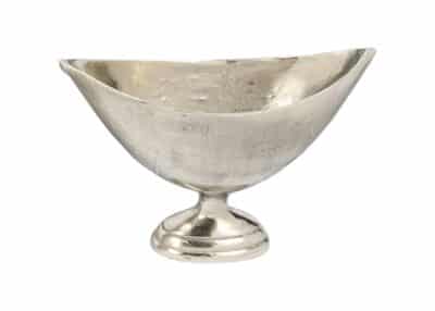 Silver metal bowl with a handle, sitting on a white surface.