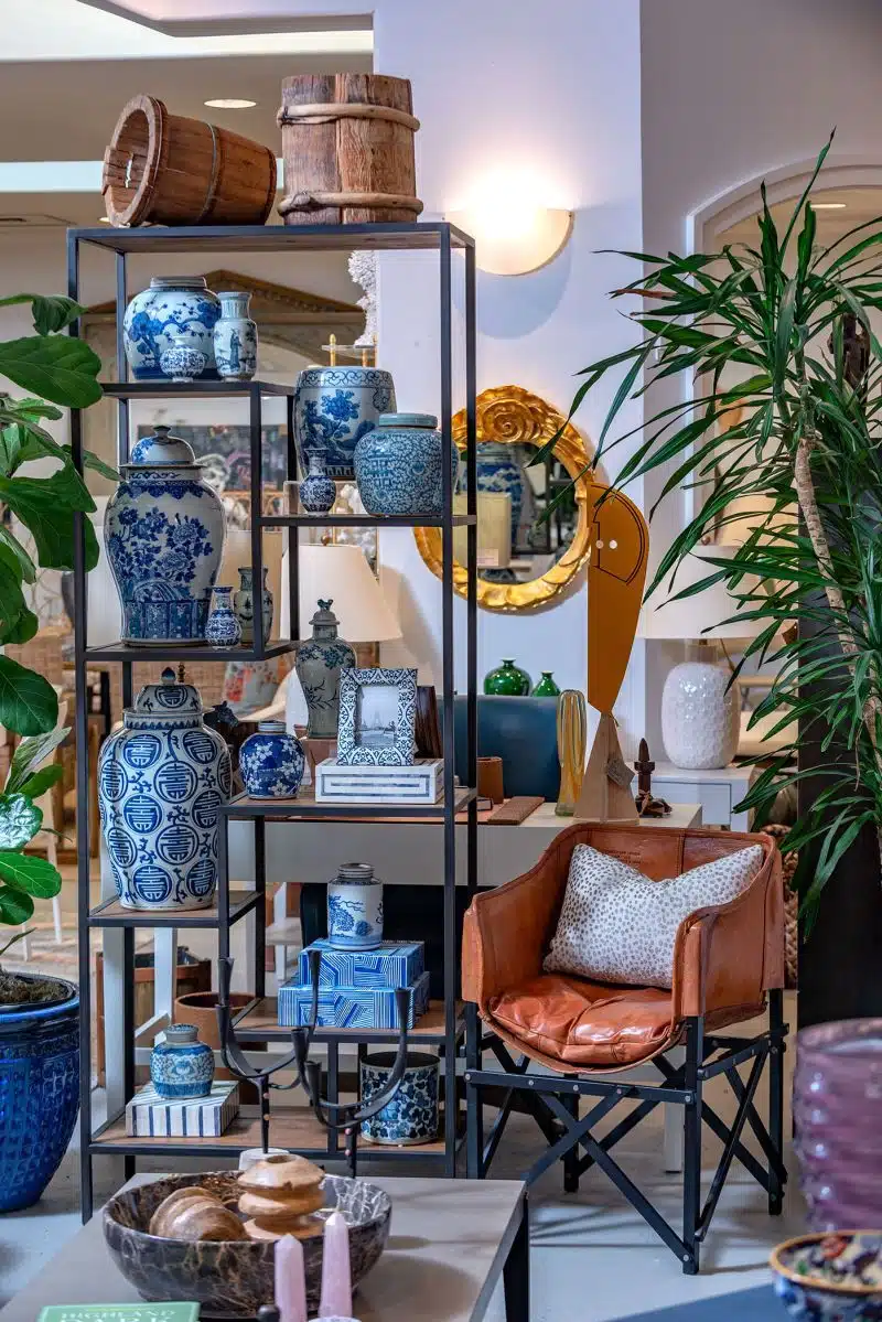 The image depicts a display case with a variety of decorative items including vases and bowls placed on shelves against a backdrop