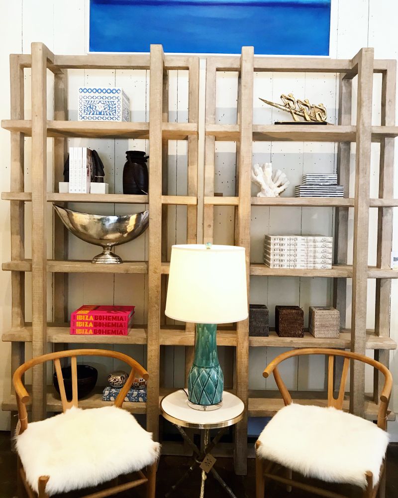 Reclaimed wood bookcase with light white wash finish, set against a blue wall backdrop.