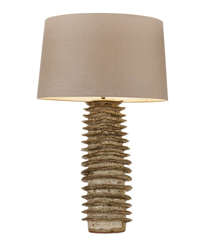 Tubular glazed ceramic lamp with a beige shade and gold base featuring a unique design element that resembles a stack of books