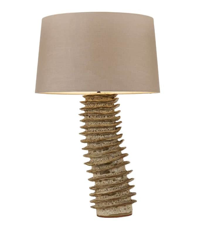 Tubular glazed ceramic lamp with a beige shade and a metal spiral base.