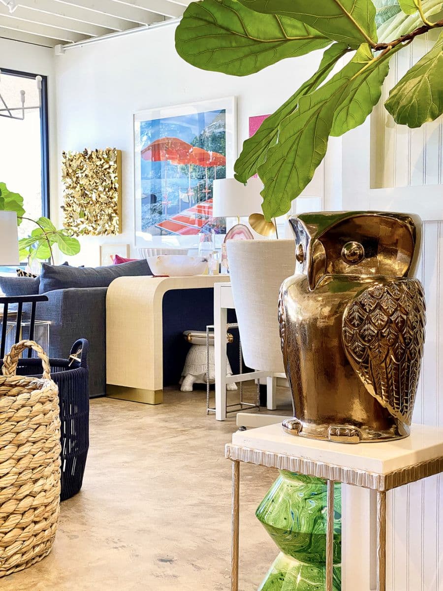Textured side table in store, golden finish, white stone top.