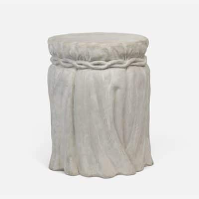 A light gray reconstituted stone outdoor faux tablecloth stool with a draped skirt, showcasing its handmade quality and slight variation in stock.
