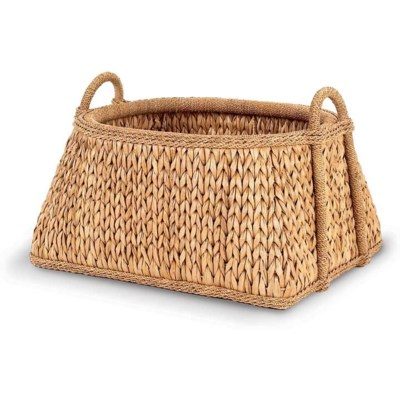 Woven seagrass basket with a handle, sitting on a white surface.