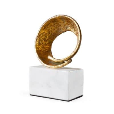 Gold circle burst statue on white marble base.