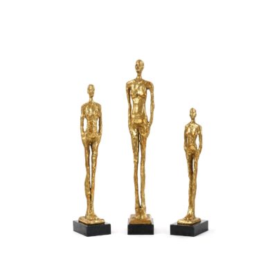 Three gilded statues on black marble bases, posing in a row.