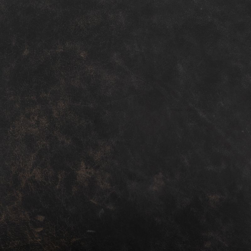 Ebony leather arm chair with brass frame, showcasing its luxurious texture and rich color.
