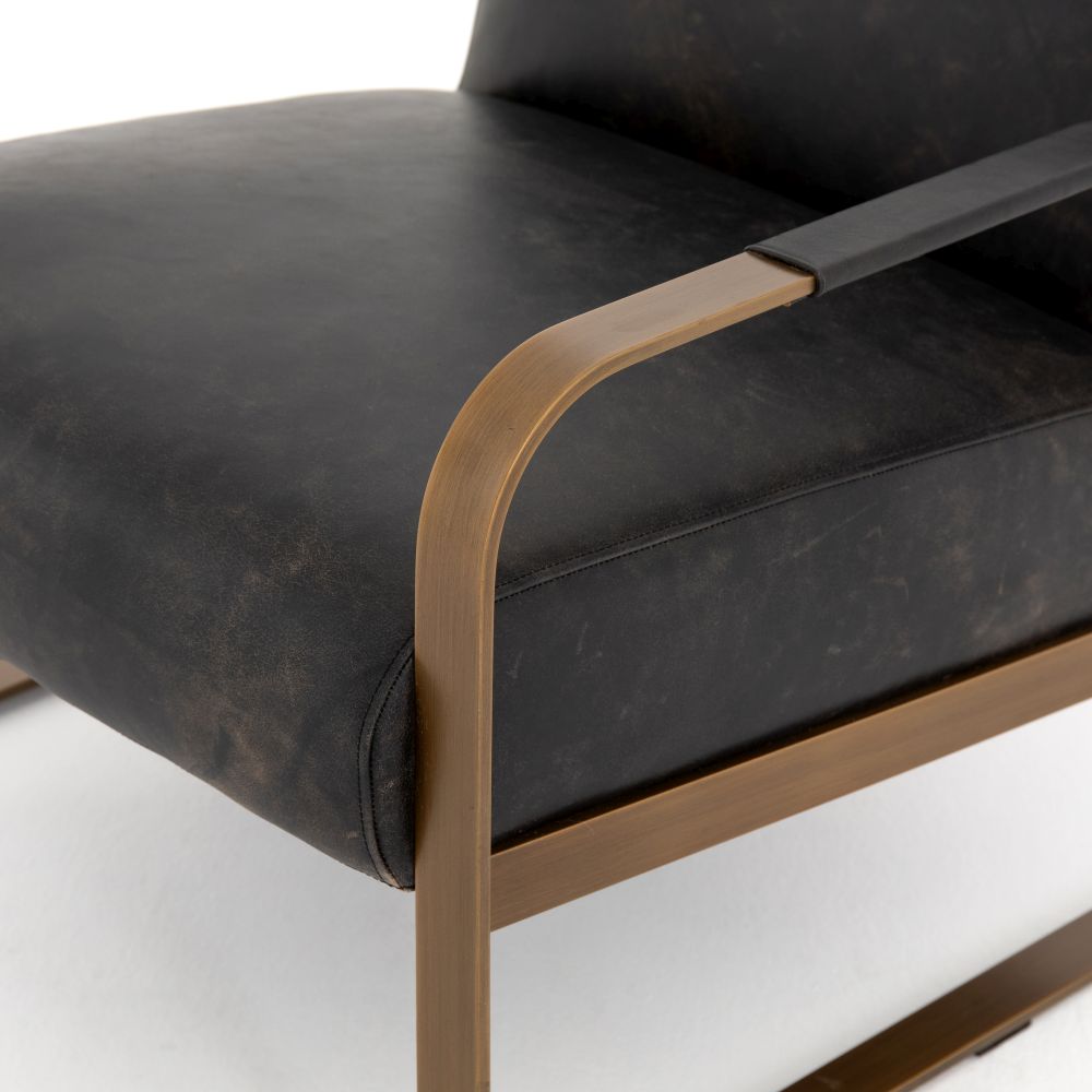 Elegant ebony leather armchair with brass frame, featuring a curved backrest and armrests.