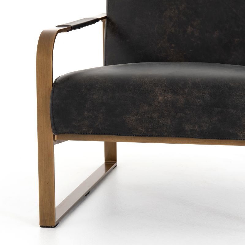 Ebony leather armchair with brass frame, showcasing a sleek and modern design.