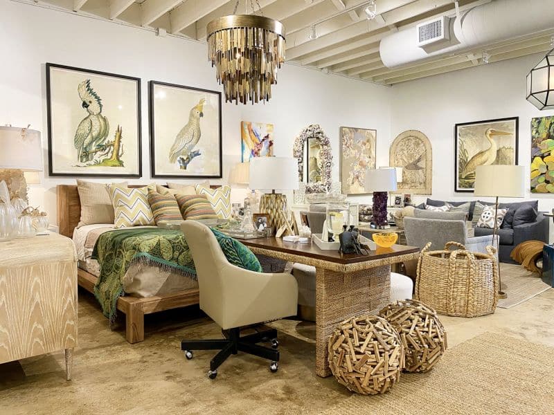 The image showcases a luxurious living room with a focus on a large framed painting of a cockatoo perched on a branch