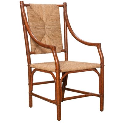 The image features a Charlotte Tortoise Rattan Arm Chair with a woven rush seat and back presented in a side view angle