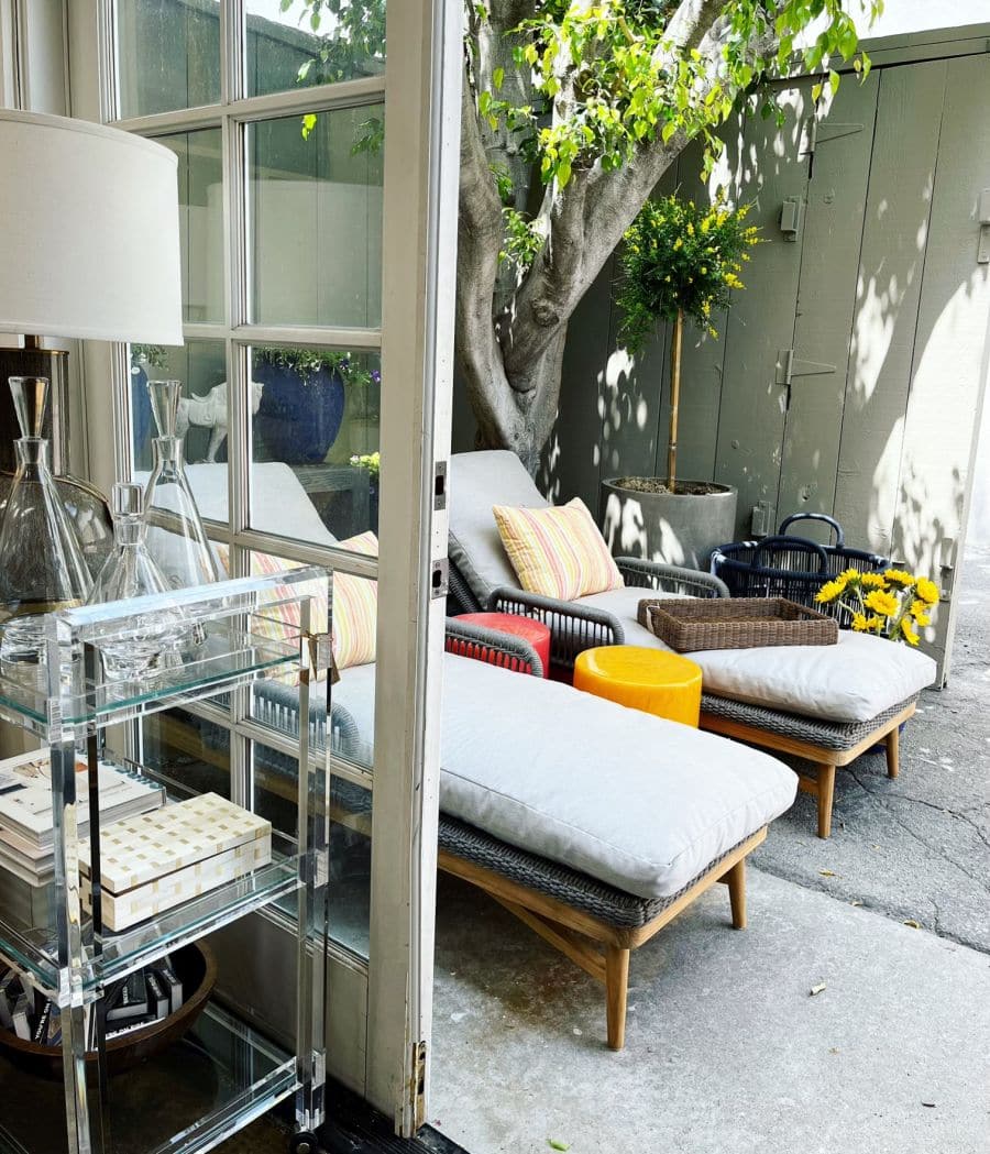 Chic outdoor chaise lounge with natural twisted wicker and teak frame, upholstered in elegant slate rope fabric, positioned on a patio.