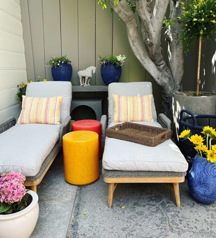 This image showcases an inviting outdoor setting featuring a natural twisted faux wicker and teak frame chaise lounge with white fabric The