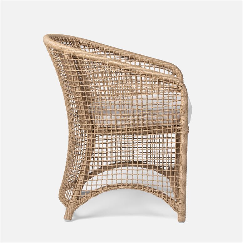Brown wicker armchair with white fabric, curved frame design.